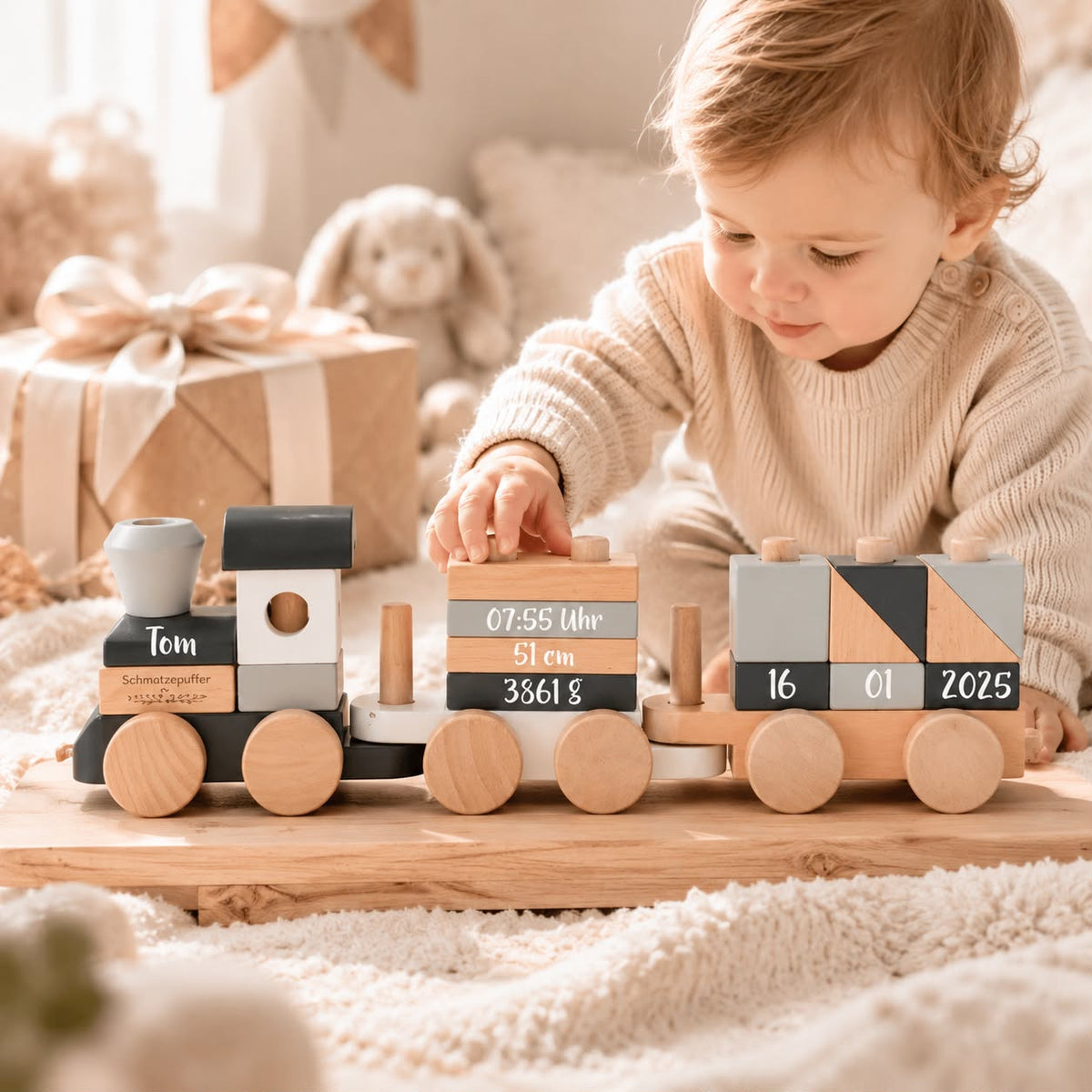 Baby mit personalisiertem Holzzug zur Geburt mit Name und Geburtsdaten als besondere Geschenkidee