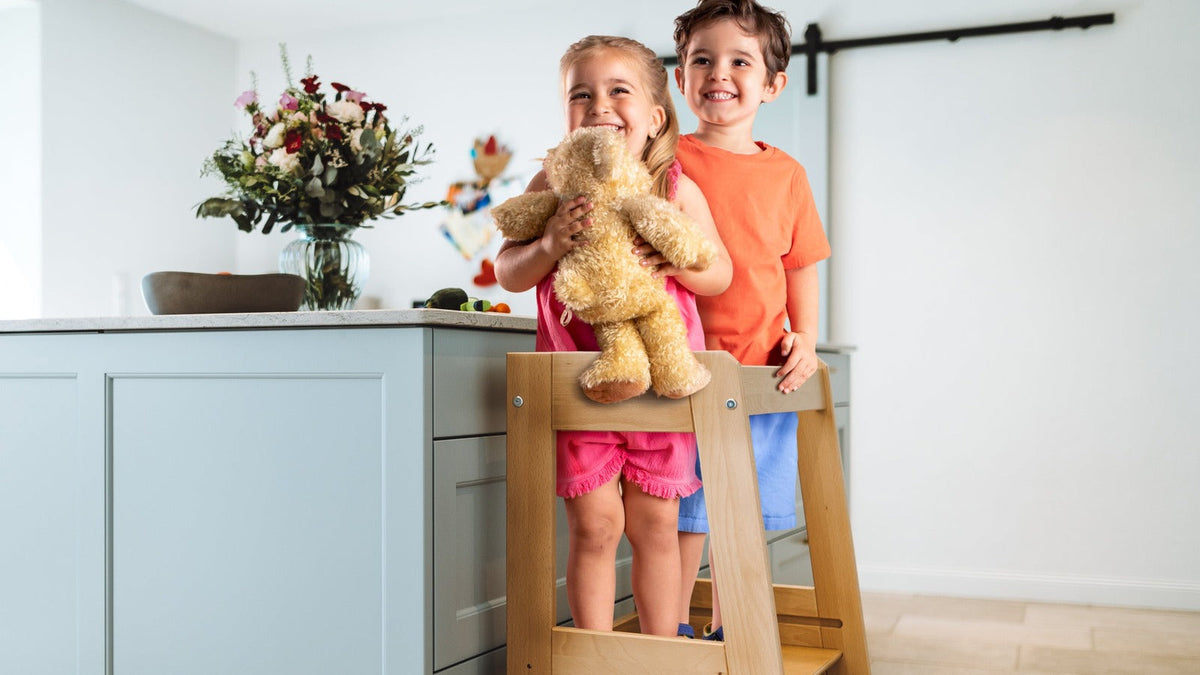 Zwei Kinder stehen gemeinsam im tiSsi Geschwister-Lernturm Felix an der Kücheninsel